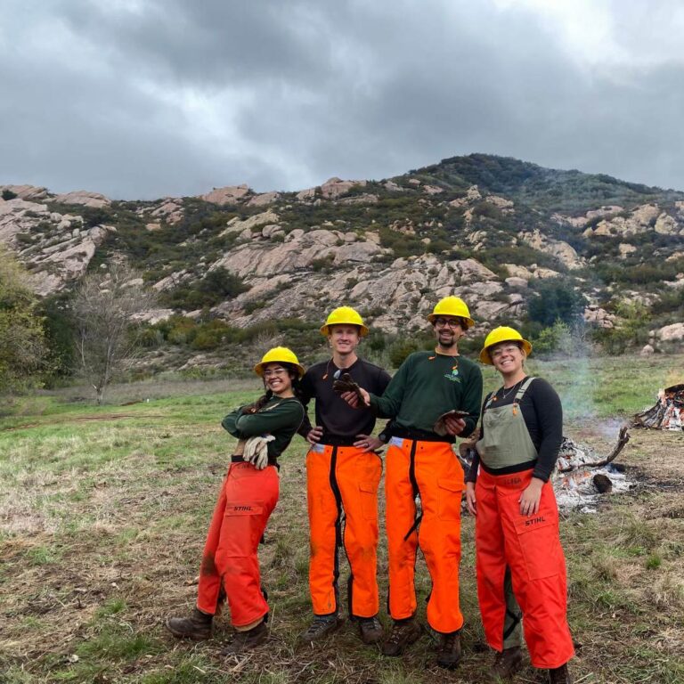 VCRCD staff posing for a picture near a burn pile
