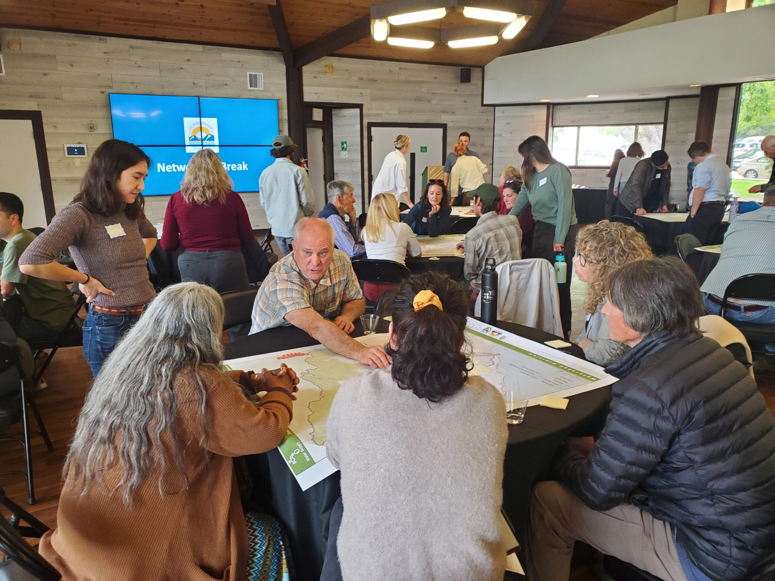 image of forum participants discussing around a map